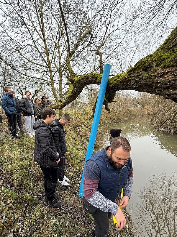 Gruppe von Menschen beobachtet einen Fluss Menschen am Ufer eines Flusses