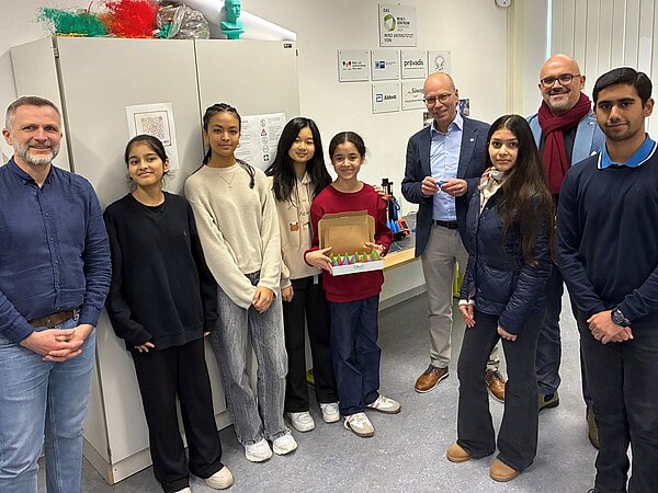 Schüler und Lehrer posieren in einem Klassenzimmer Gruppe von Personen in einem Raum